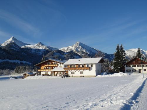 a building in the snow with mountains in the background at Tyroler Hof in Grän