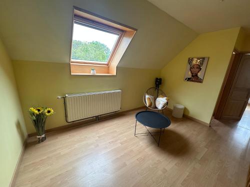 Cette chambre comprend une table, une fenêtre et une chaise. dans l'établissement La Maison des Oiseaux Résidence Pernes en Artois, à Pernes