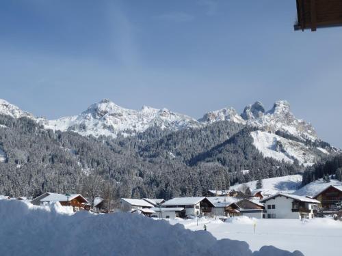 a village covered in snow with mountains in the background at Tyroler Hof in Grän
