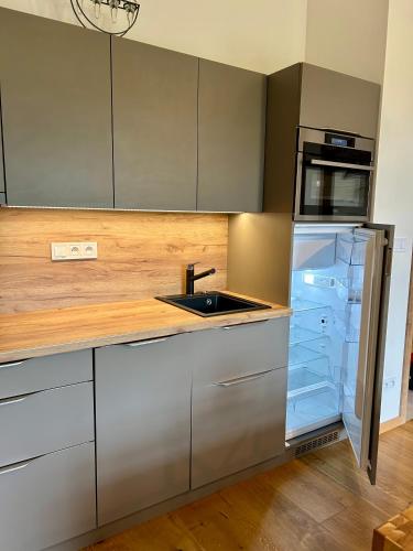 an empty kitchen with a refrigerator and a sink at Strunzova Pila - apartmány s wellness 2,06 a 3,03 in Kvilda