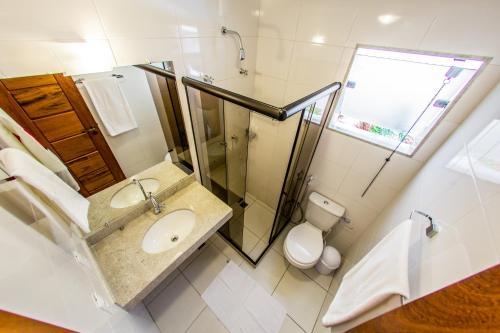 a bathroom with a sink and a shower and a toilet at Residencial Portinari LTDA in Porto Seguro