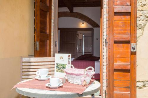 a table with two cups and a basket on it at Garden Relais Le Fontanelle in Montescudaio