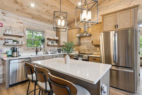 a kitchen with a large kitchen island with chairs at Golden Oaks Cabin home in Walland
