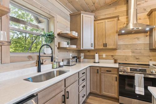 a kitchen with wooden cabinets and a sink and a window at Golden Oaks Cabin home in Walland