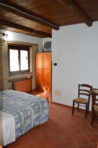 a bedroom with a bed and a table and chairs at Tenuta le Cascine in Casalbuono