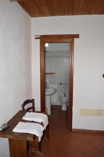 a bathroom with a table and a sink and a toilet at Tenuta le Cascine in Casalbuono