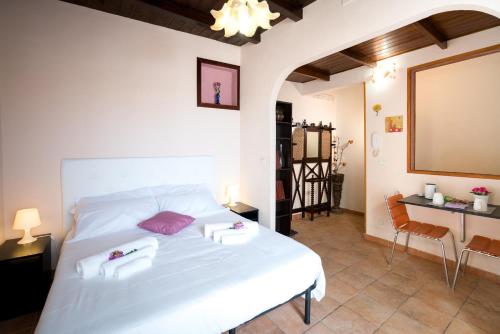 una camera da letto con un letto bianco e asciugamani di Le Scale Sul Barocco a Ragusa