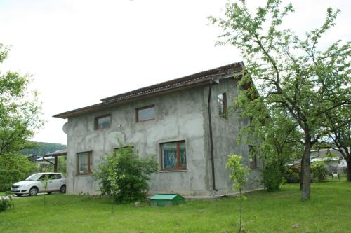 a house with a car parked in front of it at Sadiba Pri Dorogi in Kosiv