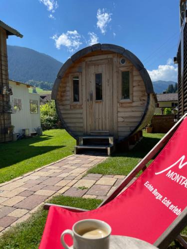 a cup of coffee sitting on a table in front of a round house at Haus Berta, Montafon in Partenen