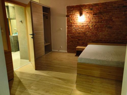 a bedroom with a bed and a brick wall at 1904 Studio in Świnoujście