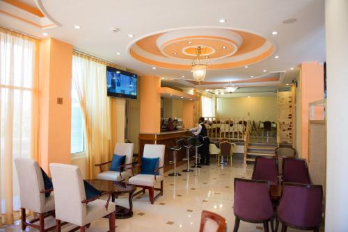 a restaurant with chairs and a table and a bar at C Fun Addis Hotel in Addis Ababa