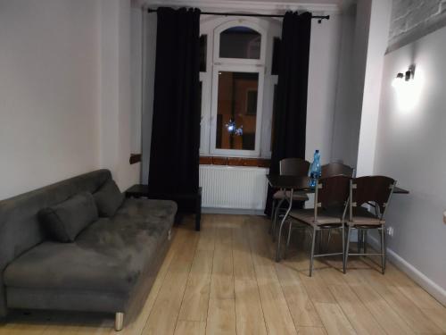 a living room with a couch and a table and a window at 1904 Studio in Świnoujście