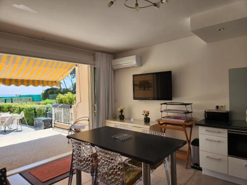 une cuisine avec une table et une vue sur un patio dans l'établissement Bandol, T3, les pieds dans l'eau, presqu'île du Capelan, à Bandol