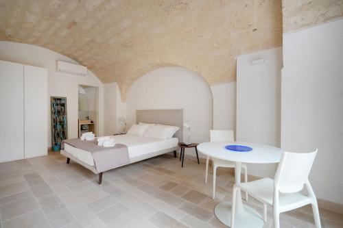 a bedroom with a bed and a table and chairs at Palazzo della Torre - Seaview Luxury historical apartments in Bari