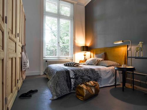 a bedroom with a bed with a bag on the floor at Queen Christine in Villeneuve d'Ascq