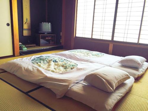 เตียงในห้องที่ Ryokan Kaminaka
