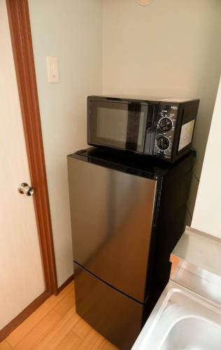 a microwave sitting on top of a refrigerator at GS63 名古屋 栄Areaおしゃれな和洋ルーム観光ビジネス周辺アクセス最高 in Nagoya