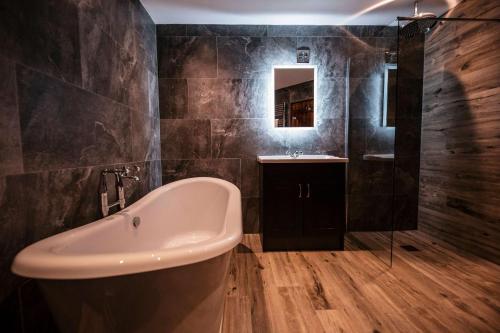 a bathroom with a bath tub and a sink at South Causey Inn in Stanley