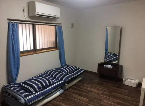 a bed in a room with a window and a mirror at 花迹民宿二号馆201 通天阁天王寺步行圈 心斋桥日本桥4分钟车程 in Osaka