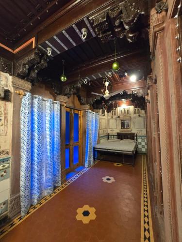 a room with a bed and blue curtains at The Prince Haveli in Bikaner