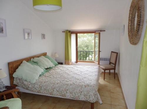 a bedroom with a bed and a window and a chair at Vacances en Provence in Pontevès