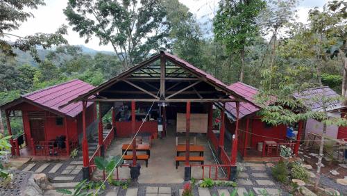 a red building with a table and chairs in front of it at Happy Monkeys Village in Sidomukti