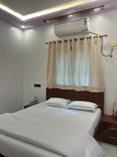 a bedroom with a white bed and a window at Mangala Residency in Cola