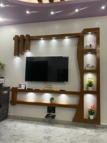 a living room with a television on a wall at Mangala Residency in Cola