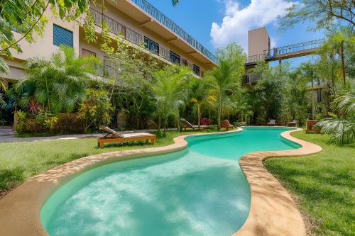 a swimming pool in front of a building at Aldea Zama - Lujo Natural en el Corazón de Tulum in Tulum