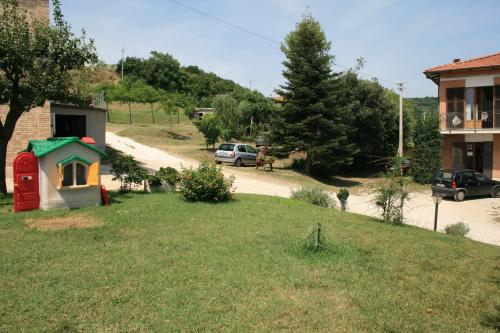 a yard with a house and a red phone booth at Da Zarè in Campofilone