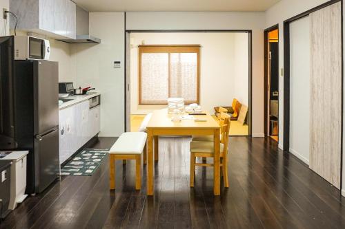 a kitchen with a table and chairs in a room at Imagine Annex in Kyoto