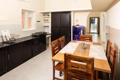a kitchen with a wooden table and chairs at Chitralayam Home stay in Guruvāyūr