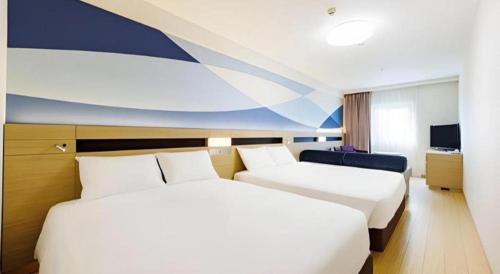 a hotel room with two beds and a tv at Hotel Dream Gate Maihama in Chiba