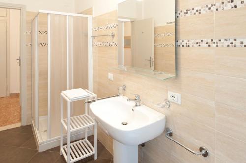 a bathroom with a white sink and a mirror at Gardenia Guest House in Forlì