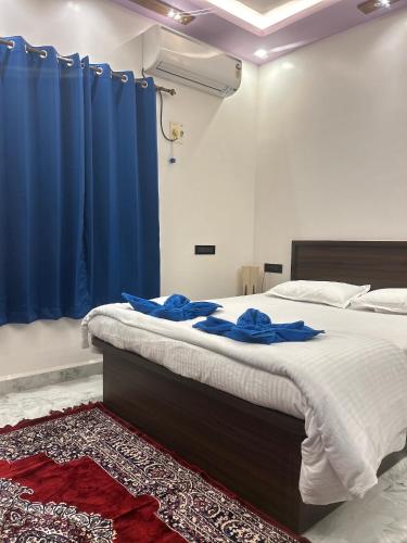 a bedroom with a large bed with blue curtains at Mangala Residency in Cola