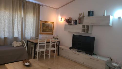 a living room with a television and a dining room table at Italian style Apartment in Durrës