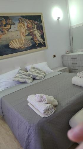 a bedroom with two beds with towels and a painting at Italian style apartament in Durrës