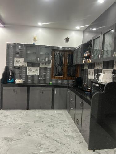 a large kitchen with gray cabinets and a sink at Mangala Residency in Cola
