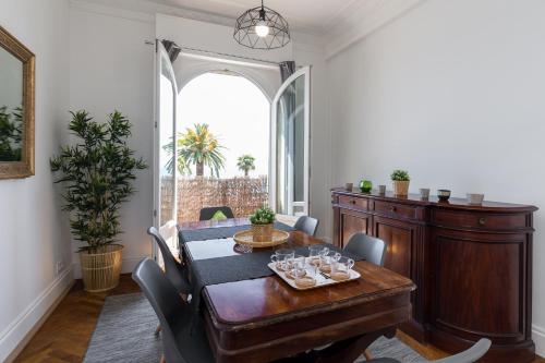 a dining room with a table and a large window at Beautiful apartment by the sea front in Nice