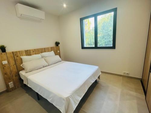 a bedroom with a large white bed with a window at Les gîtes de Sandrella in Mouans-Sartoux