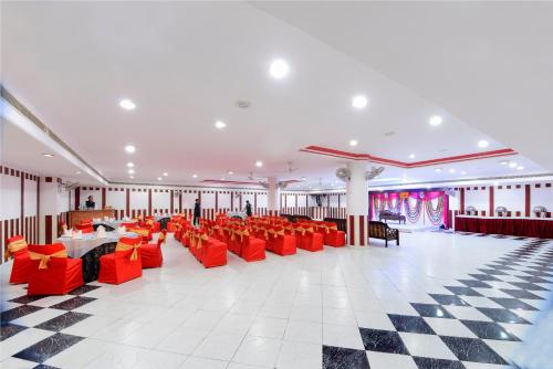 a banquet hall with red chairs and a checkered floor at Hotel Ashish Palace in Agra