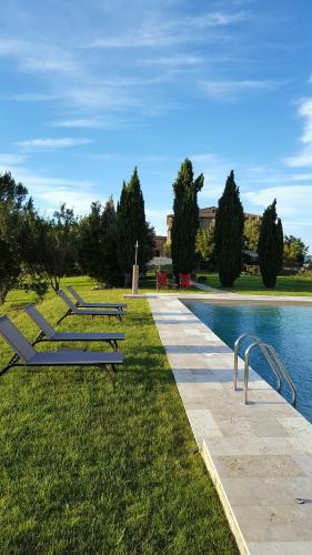 a row of benches next to a swimming pool at Locanda Cugnanello in Anqua