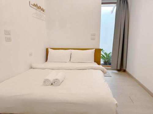 a bedroom with a bed with two towels on it at SherVa101 Home and Hostel in Chiang Mai