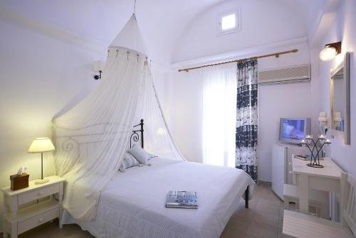 a bedroom with a large bed and a large window at Hotel Matina in Kamari