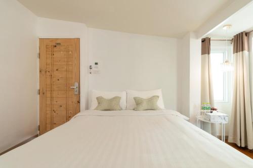 a bedroom with a large white bed with two pillows at SherVa101 Home and Hostel in Chiang Mai