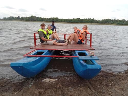 a group of people sitting on a raft in the water at Sahan Tourist House in Polonnaruwa