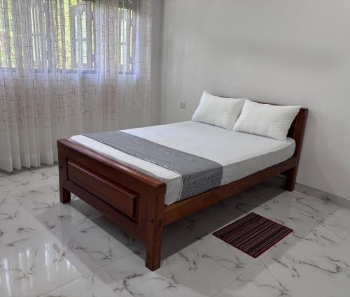 a bed in a bedroom with a white wall at coco haven in Habaraduwa