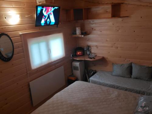 a bedroom with a bed and a tv on the wall at Pirts,kubls,,Saknēs,, in Talsi