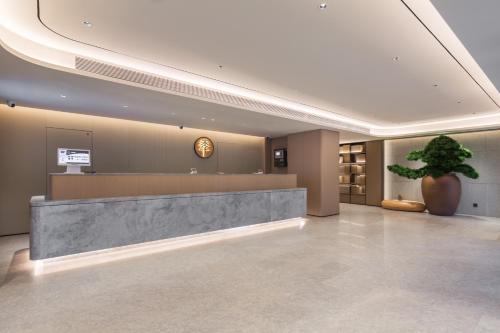 a lobby with a reception desk and a potted plant at JI Hotel Beijing Bird's Nest Liudaokou Subway Station in Beijing