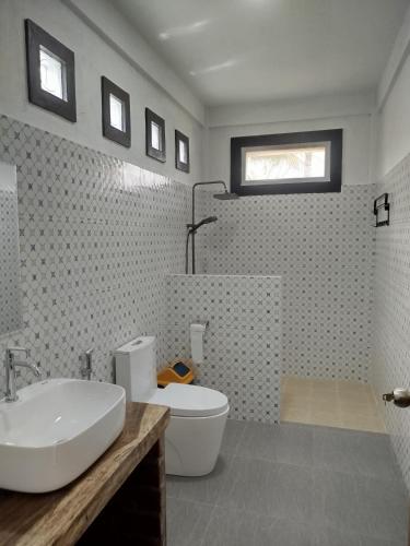 a bathroom with a white sink and a toilet at ARISTA Homestay in Tetebatu